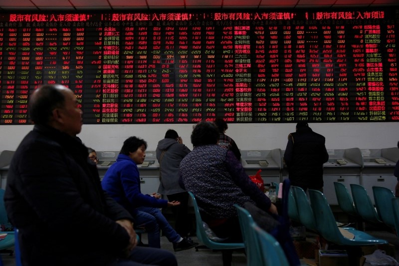 Investors look at an electronic board showing stock information on the first trading day after the New Year holiday at a brokerage house in Shanghai, China, January 3, 2017. REUTERS/Aly Song