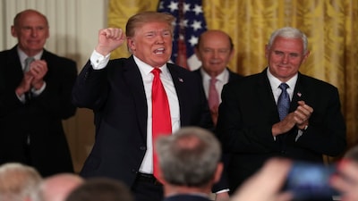 U.S. President Donald Trump, flanked by Director of National Intelligence Daniel Coats, U.S. Commerce Secretary Wilbur Ross and ‪U.S. Vice President Mike Pence‬, pumps his fist at the conclusion of his remarks at a meeting of the National Space Council at the White House in Washington, U.S. June 18, 2018. REUTERS/Jonathan Ernst