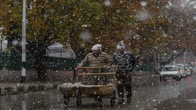 Kashmiri men push a handcart during the season's first snowfall in Srinagar, Indian controlled Kashmir, Saturday, Nov. 3, 2018. Snowfall in the Indian portion of Kashmir has disrupted power supply, air traffic, and road traffic between Srinagar and Jammu, the summer and winter capitals of India's Jammu-Kashmir state, according to news reports. (AP Photo/Dar Yasin)