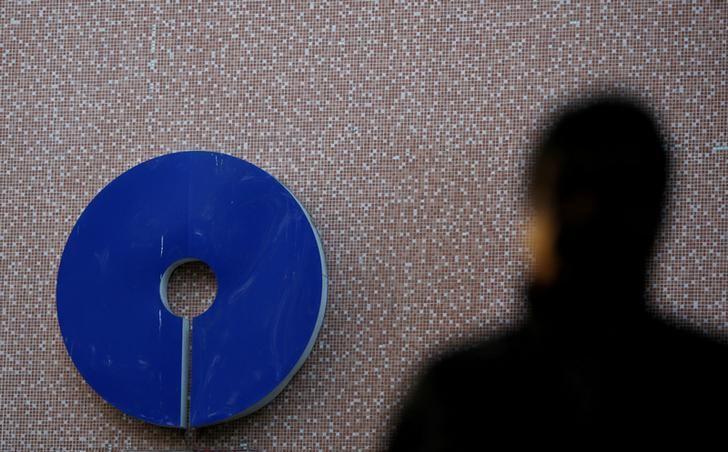 A man walks past a logo of State Bank of India outside a branch in New Delhi
