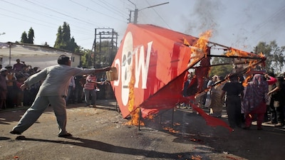 A demonstrator throws kerosene oil on an effigy depicting Dow Chemical Company, which now owns Union Carbide, to burn it during a protest to mark the 30th anniversary of Bhopal gas tragedy in Bhopal December 3, 2014. In the early hours of December 3, 1984, around 40 metric tonnes of toxic methyl isocyanate gas accidentally leaked from a pesticide factory owned by U.S. multinational Union Carbide Corp. and was carried by the wind into the surrounding slums. The government recorded 5,295 deaths. Activists estimate 25,000 people have died from illnesses in the years since. Many more, they said, are dealing with cancer, blindness, respiratory difficulties and immune and neurological disorders, but with no support.  REUTERS/Thomson Reuters Foundation/Nita Bhalla (INDIA - Tags: CIVIL UNREST DISASTER SOCIETY) - GM1EAC31N4801