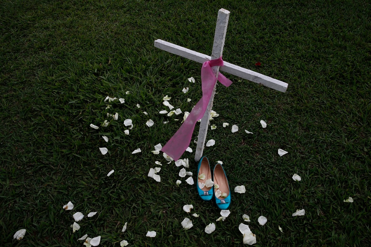 In this Nov. 25, 2019 photo, a cross and women's shoes are displayed in front of the National Congress headquarters to call the officials' attention to the high rate of violence against women in the country, in Brasilia, Brazil. Demonstrations are being held around the world on occasion of the International Day for the Elimination of Violence against Women. (AP Photo/Eraldo Peres)