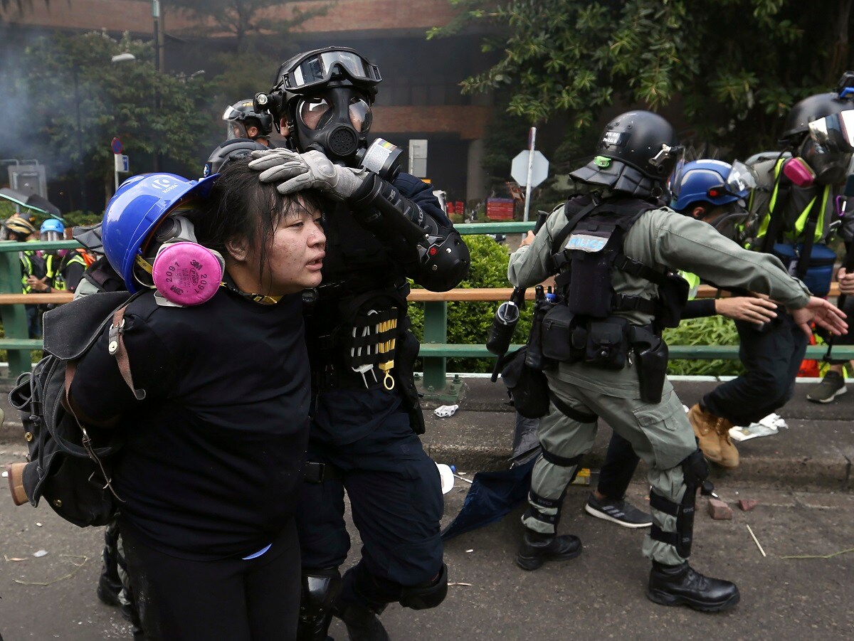 In this Monday, Nov. 18, 2019, file photo, riot police detain protesters at Hong Kong Polytechnic University in Hong Kong. About 100 anti-government protesters remained holed up at the university Tuesday as a police siege of the campus entered its third day. (AP Photo/Achmad Ibrahim, File)