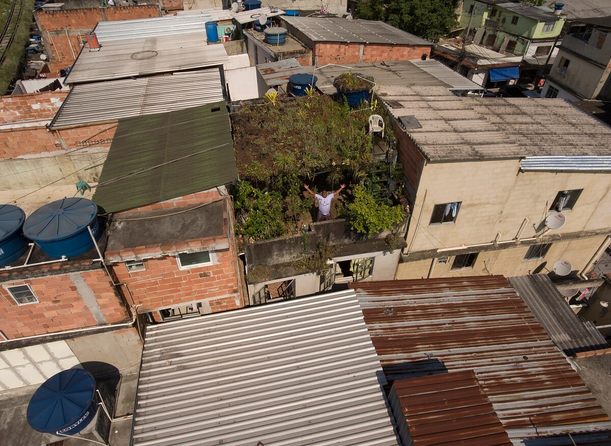 This photo published this past week but taken on Jan. 10, 2020, Luis Cassiano shows him standing on his home's green roof in Arara Park favela, Rio de Janeiro, Brazil. Cassiano said he felt the temperature rise to a point that became unbearable, and online research for a solution led him to install a green roof. (AP Photo/Renato Spyrro)