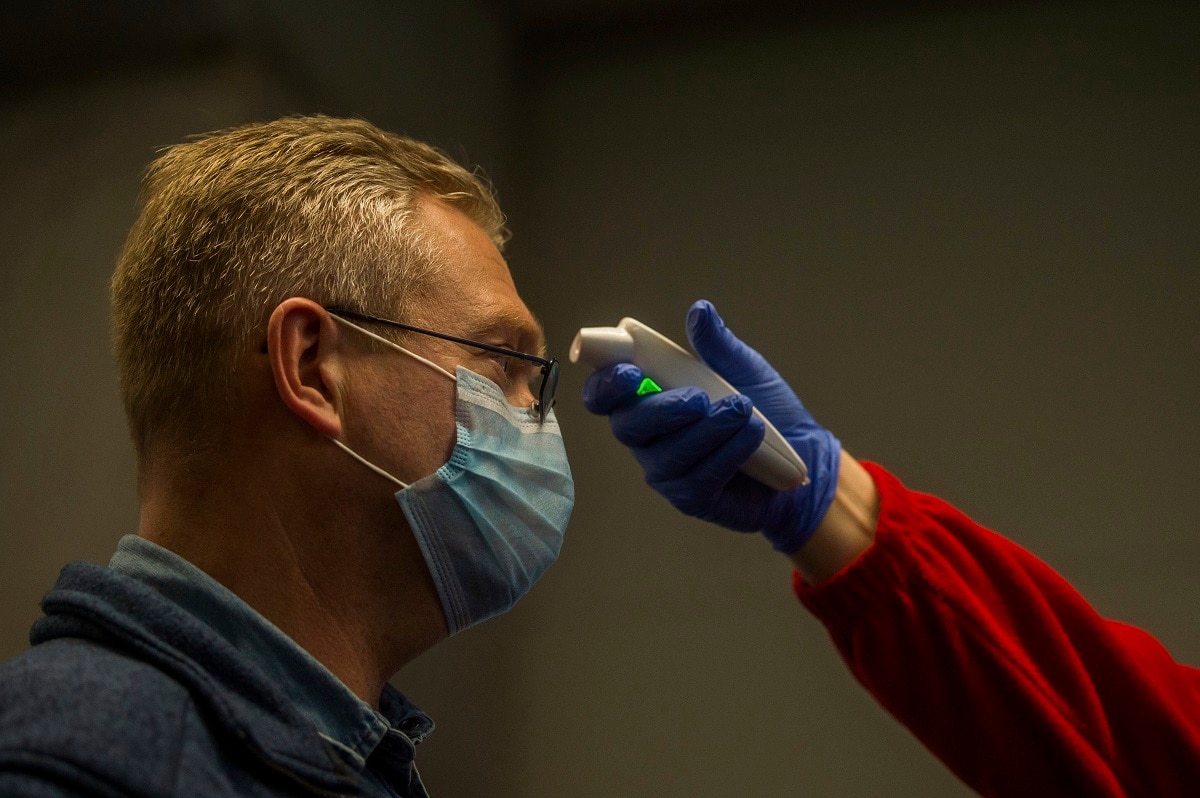 The temperature of a person is checked as precautionary measures against the spreading of novel coronavirus, at Budapest Liszt Ferenc International Airport in Budapest, Hungary, Wednesday, Feb. 5, 2020. So far almost 900 passenger arriving directly from China have been examined at the airport. (Zoltan Balogh/MTI via AP)