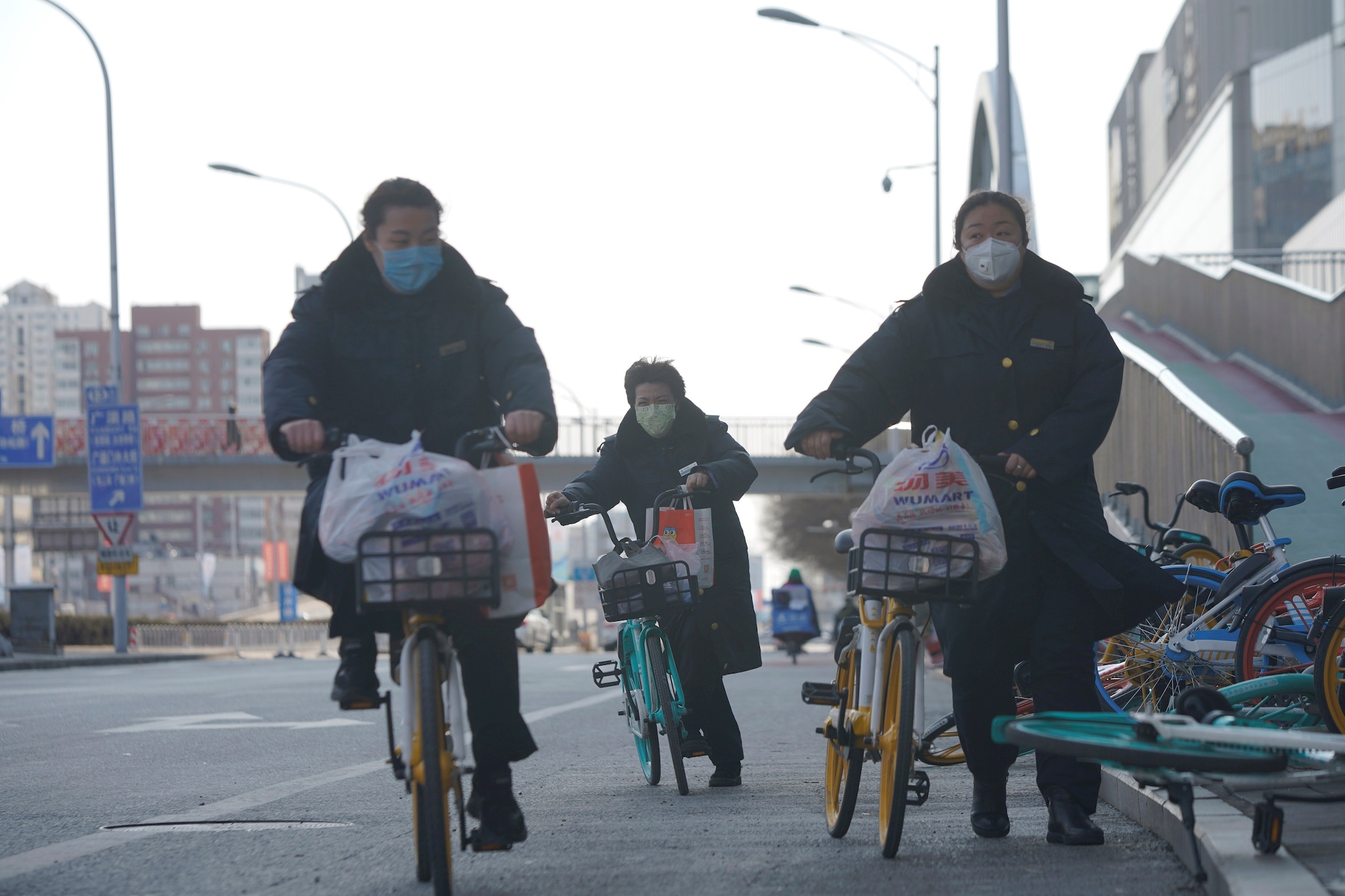 Women wearing face masks ride shared bicycles, as the country is hit by an outbreak of the novel coronavirus, in Beijing, China February 15, 2020. REUTERS/Stringer