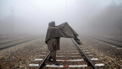 Amritsar: A man crosses railway tracks during a cold and foggy morning, in Amritsar, Friday, Dec. 25, 2020. (PTI Photo)  (PTI25-12-2020_000150B)