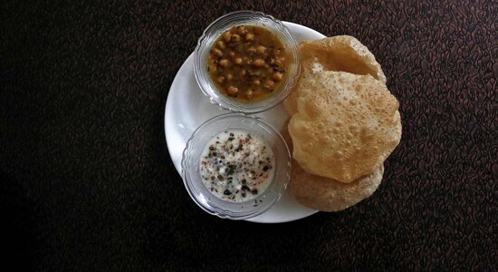 No 8. Chole Bhature | A popular street food from North India, pairs spicy chickpea curry (chole) with deep-fried bread (bhature), known for its hearty flavors and satisfying crunch, often served with tangy pickles and onions for a delightful combination of textures and tastes. (Image: Shutterstock)