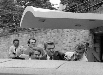 FILE - President Ronald Reagan waves and then looks up before being shoved into the President's limousine by secret service agents after being shot outside a Washington hotel, March 30, 1981. The assassination attempt of former President Donald Trump has parallels to the last time a president or presidential candidate was wounded — in 1981 when Ronald Reagan was nearly killed by an assailant's bullet. Reagan's life was spared thanks to the quick actions of a Secret Service agent and the skill of doctors and nurses at a Washington, D.C., hospital. (AP Photo/Ron Edmonds, File)