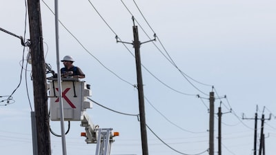 An Xfinity telecommunications company employee repairs cables in the aftermath of Hurricane Beryl in Surfside Beach, Texas, U.S., July 8, 2024. REUTERS/Adrees Latif
