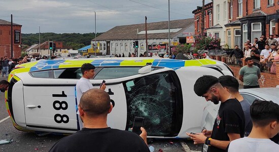 A police vehicle lies on its side during unrest in Harehills, Leeds, Britain, July 18, 2024 in this picture obtained from social media. @robin_singh via Instagram/via REUTERS THIS IMAGE HAS BEEN SUPPLIED BY A THIRD PARTY. MANDATORY CREDIT.