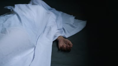Hand of dead woman lying down under white cloth covered death body from murder at house of victim,Horror and crime scene.