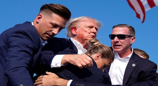 Republican presidential candidate former President Donald Trump is surrounded by U.S. Secret Service agents as he leaves the stage at a campaign rally, Saturday, July 13, 2024, in Butler, Pa. (AP Photo/Evan Vucci)