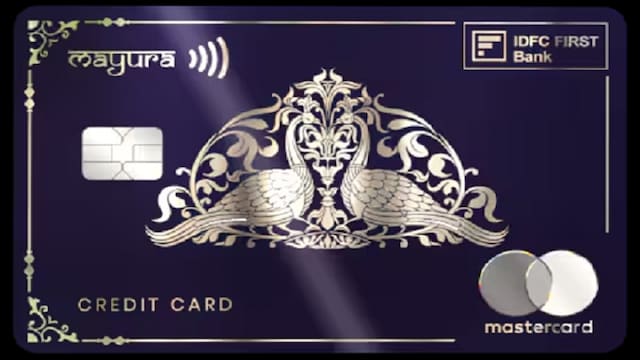 The IDFC FIRST Bank Mayura Metal Credit Card offers zero foreign currency markup and up to eight complimentary lounge or spa visits per quarter, covering both domestic and international locations, along with railway lounge access. The card provides travel insurance and trip cancellation coverage up to ₹50,000, reward points redeemable for travel, dining, and lifestyle expenses, and additional benefits including fuel surcharge waiver and roadside assistance. The IDFC FIRST Bank Mayura Metal Credit Card offers zero foreign currency markup and up to eight complimentary lounge or spa visits per quarter, covering both domestic and international locations, along with railway lounge access. The card provides travel insurance and trip cancellation coverage up to ₹50,000, reward points redeemable for travel, dining, and lifestyle expenses, and additional benefits including fuel surcharge waiver and roadside assistance.