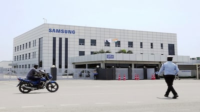 A motorcyclist rides past Samsung company plant in Sriperumbudur, on the outskirts of Chennai, India, Tuesday, Sept. 24, 2024. (AP Photo/Mahesh Kumar A.)