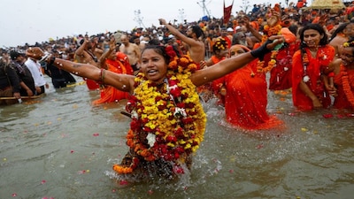 A Sadhvi or a Hindu holy woman reacts as she takes a holy dip during the "Maha Kumbh Mela", or the Great Pitcher Festival, in Prayagraj, India, January 14, 2025. REUTERS/Anushree Fadnavis