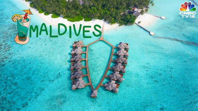 Image: A small island covered by palms and surrounded by turquoise blue water, and beautiful corals in Maldives from Swisshippo via Canva.