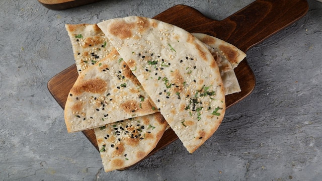 No 4. Dish: Naan | Origin: Central Asia / Persia | The most popular Indian flat bread, the naan is considered an classic and was first created by Persian and Central Asian chefs during the Mughal era and was served at royal meals in tandoors. Although naan has various regional variations from India, such as cheese, or butter-garlic, the bread itself is a delicious import.(Image: Shutterstock) No 4. Dish: Naan | Origin: Central Asia / Persia | The most popular Indian flat bread, the naan is considered an classic and was first created by Persian and Central Asian chefs during the Mughal era and was served at royal meals in tandoors. Although naan has various regional variations from India, such as cheese, or butter-garlic, the bread itself is a delicious import.(Image: Shutterstock)
