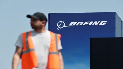 FILE PHOTO: A worker walks past a Boeing logo before the opening of the 55th International Paris Airshow at Le Bourget Airport near Paris, France, June 13, 2025. REUTERS/Benoit Tessier/File Photo