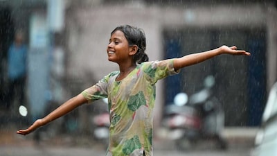 A girl plays in rain, in Bikaner, Rajasthan. (PTI)