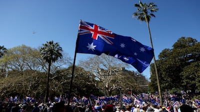 Demonstrators carry Australian flags during the 'March for Australia' anti-immigration rally, in Sydney, Australia, August 31, 2025. REUTERS/Hollie Adams