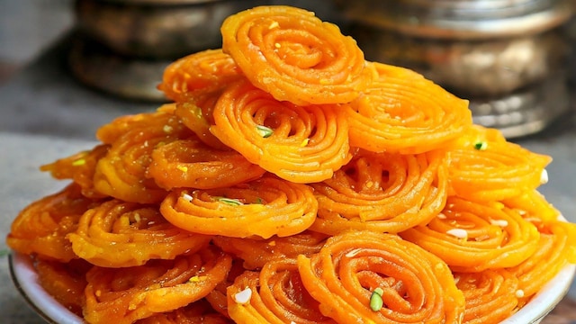 Crispy jalebi with pistachios served on white plate Crispy jalebi with pistachios served on white plate