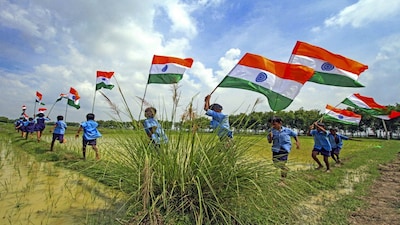 Birbhum: School children carrying Indian national flags run along a paddy field, on the eve of the Independence Day, at Bergram, in Birbhum district, West Bengal, Thursday, Aug. 14, 2025. (PTI Photo) (PTI08_14_2025_000460B)