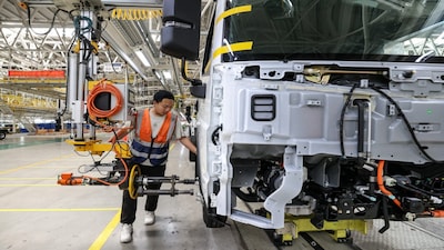 An employee works on a production line manufacturing electric trucks at a factory in Gui'an New Area, Guizhou province, China July 2, 2025. cnsphoto via REUTERS ATTENTION EDITORS - THIS IMAGE WAS PROVIDED BY A THIRD PARTY. CHINA OUT. NO COMMERCIAL OR EDITORIAL SALES IN CHINA