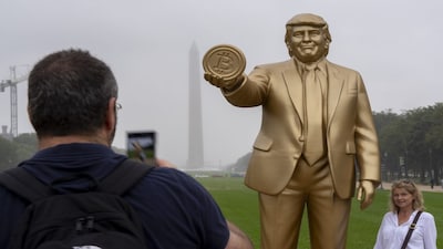 A statue of President Donald Trump holding a bitcoin in recognition of his support for cryptocurrency is displayed on the National Mall with the Washington Monument behind, Wednesday, Sept. 17, 2025, in Washington. (AP Photo/Alex Brandon)