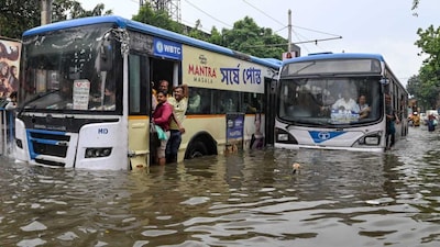 Buses move through a flooded road after heavy rainfall, in Kolkata. (PTI)