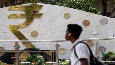 FILE PHOTO: FILE PHOTO: A man walks past an installation of the Rupee logo and Indian currency coins outside the Reserve Bank of India (RBI) headquarters in Mumbai, India, April 9, 2025. REUTERS/Francis Mascarenhas/File Photo/File Photo