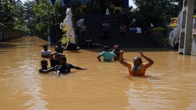 People wade through a flooded street, following Cyclone Ditwah in Kelaniya, Sri Lanka, November 30, 2025. REUTERS/Thilina Kaluthotage