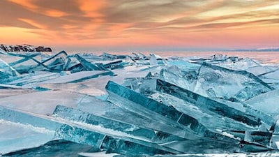Lake Baikal: Siberia’s glassy ice-sea in winter. When winter grips southern Siberia, Baikal freezes into an immense, crystal-clear ice sheet where the frozen surface sometimes reveals the lakebed, a surreal, mirror-like expanse that draws adventurers worldwide. (Image: Wikimedia Commons)