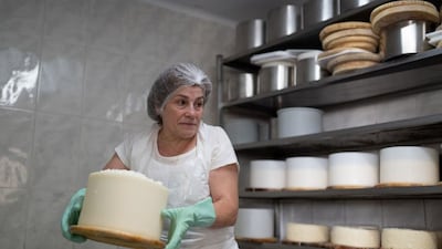 Cheesemaker Encarnacion Bada places cheese curd into a mold to produce Cabrales blue cheese at her dairy in Tielve, Spain, northern August 7, 2025. Women like Encarnacion Bada have long upheld the artisanal tradition of crafting Cabrales by hand and aging it in mountain caves, a practice now at risk as younger generations move away. REUTERS/Bernat Parera