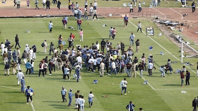 Soccer Football - Argentine soccer star Lionel Messi on a whirlwind tour of India - Vivekananda Yuva Bharati Krirangan, Kolkata, India - December 13, 2025 Riot police and fans are seen on the pitch after Argentine soccer star Lionel Messi leaves the stadium REUTERS/Sahiba Chawdhary