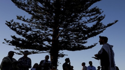 Members of the Jewish community gather for Shacharit, morning prayers, as the crime scene was reopened following the mass shooting at Bondi Beach on Sunday, in Sydney, Australia, December 19, 2025. REUTERS/Hollie Adams     TPX IMAGES OF THE DAY