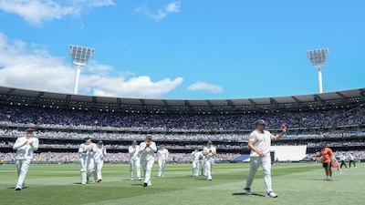Cricket - The Ashes - Australia v England - Fourth Test - MCG, Melbourne, Australia - December 26, 2025 England's Josh Tongue walks off the field raising the ball after claiming 5 wickets. REUTERS/Asanka Brendon Ratnayake