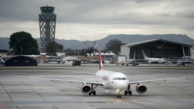An Avianca plane sit on the tarmac at El Dorado airport in Bogota on November 28, 2025. Colombian airline Avianca reported on Friday "significant" disruptions to its flights due to a required Airbus software update affecting 70 percent of the company's fleet. (Photo by Sergio Yate / AFP)