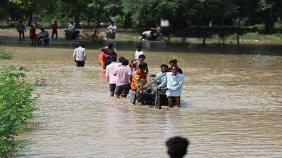 People wade through a flooded road after a rise in the water level of river Yamuna due to heavy monsoon rains, in New Delhi, India, September 3, 2025. REUTERS/Anushree Fadnavis