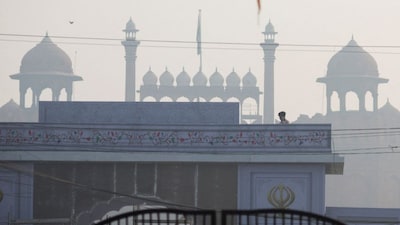 A man stands on a temporary gate in front of the historic Red Fort near the site of an explosion, in the old quarters of Delhi, India, November 11, 2025. REUTERS/Adnan Abidi