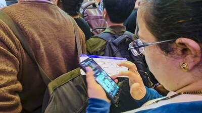 Mumbai: A stranded passenger checks her phone at the IndiGo counter after several flights were cancelled at Chhatrapati Shivaji Maharaj International Airport, in Mumbai, Friday, Dec. 5, 2025. (PTI Photo)(PTI12_05_2025_000022B)