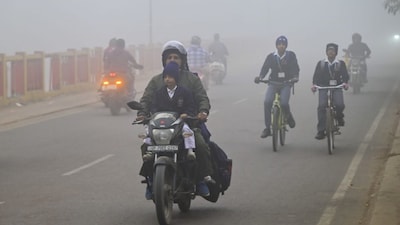 Vehicles move along a road on a foggy winter morning, in Prayagraj, Thursday, Dec. 18, 2025. (PTI Photo)
