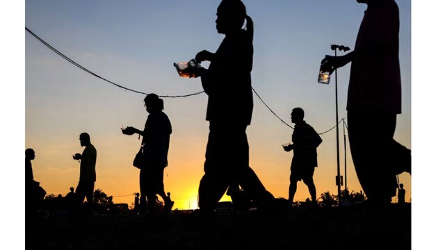 Displaced people walk after receiving food at a temporary shelter amid clashes between Thailand and Cambodia along a disputed border area, in Buriram province, Thailand, (Reuters)