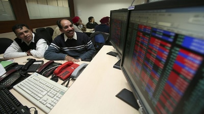 Investors watch a display at a local share market in the northern Indian city of Chandigarh December 18, 2008. Indian shares were little changed in seesaw trade on Thursday as energy stocks fell with oil trading near four-year lows, while banks climbed on rising expectations for a rate cut. Investors were awaiting inflation data due by noon, which could set the tone for the market later in the day. REUTERS/Ajay Verma (INDIA)