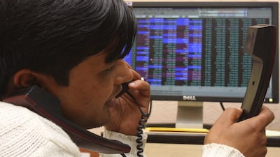 A terminal operator speaks on telephones at a local stock market in the northern Indian city of Chandigarh December 31, 2009. Indian shares hit their highest level in nearly 20 months on Thursday, led index heavyweights Reliance Industries and Infosys Technologies, and were set to post their biggest yearly gain since 1991. REUTERS/Ajay Verma (INDIA - Tags: BUSINESS)