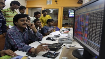 A trader works at a stock brokerage in the western Indian city of Ahmedabad November 26, 2010. India's stock market regulator is likely to announce on Friday a date and details for auctioning enhanced debt limits for foreign investors, a source with direct knowledge of the matter said. REUTERS/Amit Dave (INDIA - Tags: BUSINESS)