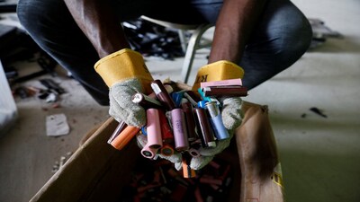 An employee holds a handful of lithium-ion cells from old laptop battery packs at the Quadloop recycling facility in Lagos, Nigeria October 4, 2022. REUTERS/Temilade Adelaja