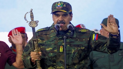 FILE PHOTO: Venezuela's President Nicolas Maduro holds Simon Bolivar's sword as he addresses members of the armed forces, Bolivarian Militia, police, and civilians during a rally against a possible escalation of U.S. actions toward the country, at Fort Tiuna military base in Caracas, Venezuela, November 25, 2025. REUTERS/Leonardo Fernandez Viloria/File Photo