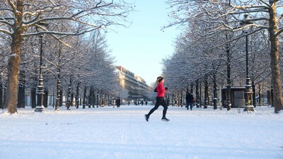 A woman jogs in the snow-covered Tuileries Garden in Paris as winter weather with snow and cold temperatures hits a large part of the country, France, January 6, 2026. REUTERS/Abdul Saboor