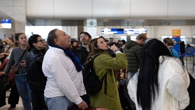 Passengers check a flight information board inside Athens' Eleftherios Venizelos international airport in Athens, Greece, Sunday, Jan. 4, 2026, as many flights were disrupted across Greece. (AP Photo/Yorgos Karahalis)